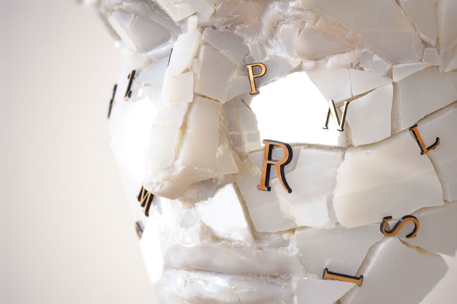 Giuseppe D'Angelo particolare della scultura un viso in onice bianco distrutto con delle lettere che creano un rebus. Opera , arte